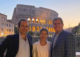 Tim Romani, Nicholas Gancikoff, and Stephanie Bax stand in front of the Colosseum in Rome.