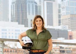 Beth Penfield standing in front of downtown Nashville with a CAA-ICON-branded hard hat