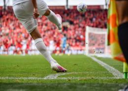 Soccer player shooting a goal in a stadium